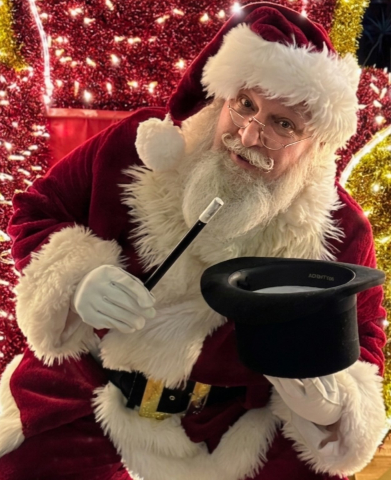 Santa Bruce holding a top hat and magic wand
